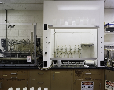 ade Doskow  Leachate Plant – Veteran’s Avenue Laboratory, 2020/2021  Archival pigment print  30h x 40w in 76.20h x 101.60w cm, interior industrial image of a laboratory in a Leachate plant, wooden counters with white machinery