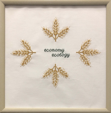 Kirsten Stolle  Economy over Ecology, 2014  Embroidery floss on aida cloth in a vintage frame  14h x 16w in -The words economy and ecology are embroidered in the center of the aida cloth