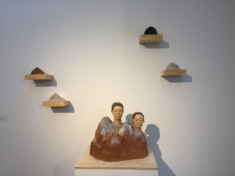 Sachiko Akiyama  Between Earth and Sky, 2012  wood, clay, paint,  17h x 17w x 17d in. a sculpture of two heads atop a range of mountains, with 4 smaller mountainous shapes mounted above