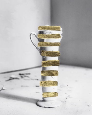 James Henkel  Repair #3, 2018  Archival Pigment Print with Gold Leaf  10h x 8w in, black and white image of a tall cup with hand painted gold leaf horizontal bands